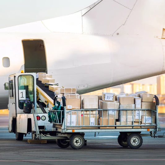Air freight operation at Dubai airport showing a cargo plane being loaded with goods, representing international shipping and logistics handled